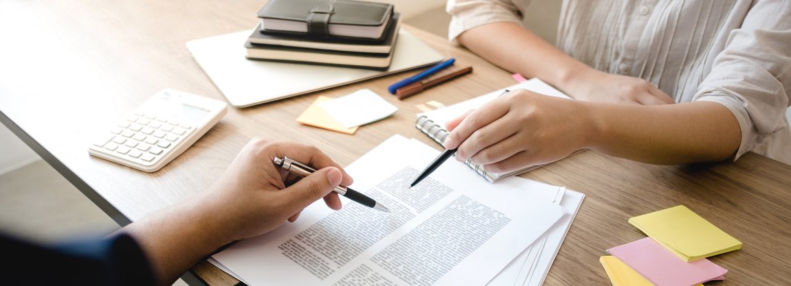Two people reviewing a document together at a desk