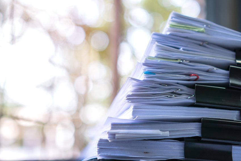 Stacks of documents held together with binder clips