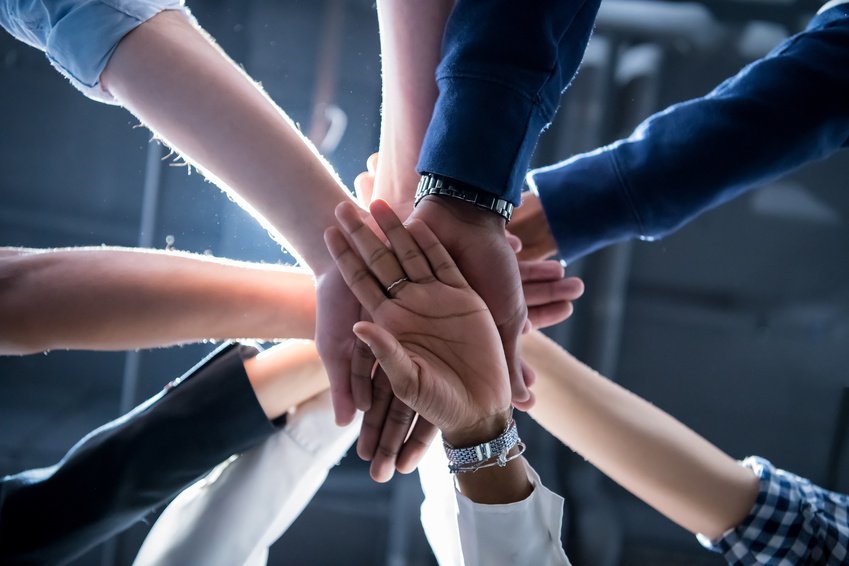 Colleagues joining their hands in a gesture of teamwork