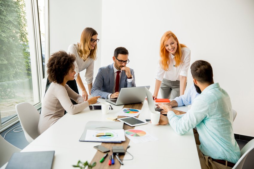 Professionals working through a project around a conference table