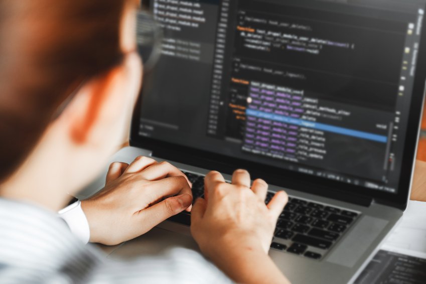 A programmer reviewing code on a computer
