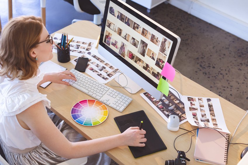 A graphic designer working with a pen tablet and computer