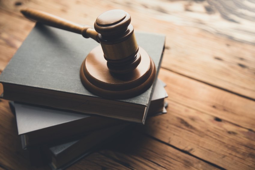 A law book and wooden judge’s gavel on a desk